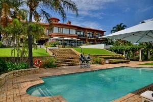 
a house with a pool and a balcony at Apogee Boutique Hotel & Spa in Pretoria
