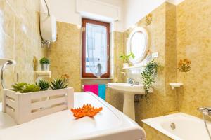 bagno con vasca bianca e lavandino di Appartamento Pineta Fronte Mare - MyHo Casa a Martinsicuro