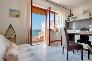 a kitchen and a living room with a view of the ocean at SARDINIA RE - Anglona Apartment in Castelsardo