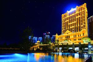 un edificio de hotel con un perfil urbano por la noche en Wyndham Grand Kunming East, en Kunming