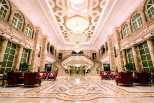 een grote lobby met rode stoelen en een kroonluchter bij Wyndham Grand Kunming East in Kunming