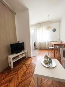 a living room with a flat screen tv and a table at Kopernik - parking available in Belgrade