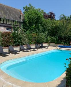 een groot blauw zwembad met ligstoelen eromheen bij Beautiful HOUSE in Trouville / Swimming Pool 12 persons in Trouville-sur-Mer