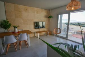 uma sala de estar com mesa e cadeiras em Laduna Tarifa Penthouse / seaview & pool em Tarifa