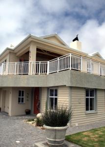 a large house with a balcony on top of it at 2 Geckos in Mossel Bay