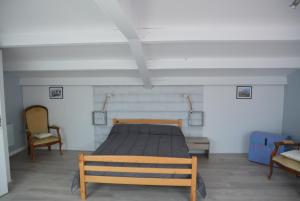 Un dormitorio con una cama y dos sillas. en FACE MER et PLAGE, entre SAINT MICHEL et SAINT BREVIN, en Saint-Michel-Chef-Chef