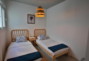 Duas camas individuais num quarto com um candeeiro. em Laduna Tarifa Penthouse / seaview & pool em Tarifa
