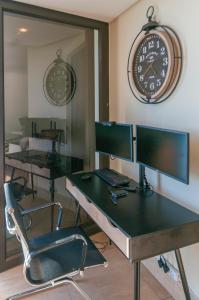 una oficina con dos escritorios y un reloj en la pared en Luxury Ocean View 1203, en Ciudad del Cabo