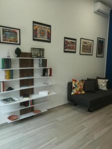 a living room with a couch and a book shelf at atocà1 casa vacanze - vedi anche atocà2 e atocà3 in Palermo