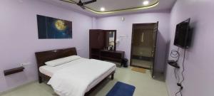 a bedroom with a bed and a television in it at BMR BALA LODGE in Nandyāl