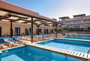 a swimming pool with chairs and a hotel at Vasia Resort & Spa in Sisi