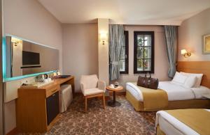 una camera d'albergo con letto e TV di Almina Guest House a Istanbul