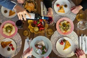 Un gruppo di persone seduti intorno a un tavolo che mangiano cibo di 21 House of Stories Città Studi a Milano