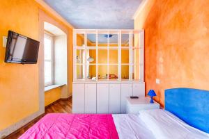1 dormitorio con 1 cama y TV en la pared en Lloyd Residence Triestino, en Trieste
