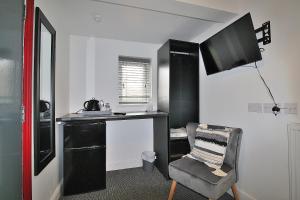 a room with a desk and a chair and a tv at Hamilton in Lincoln