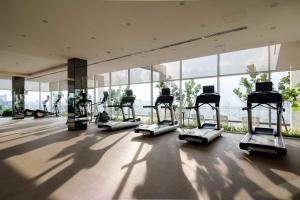 a gym with rows of treadmills in a building at Maxhome at Fraser Residence KL in Kuala Lumpur