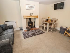 a living room with a couch and a fireplace at Primrose Cottage in Market Harborough