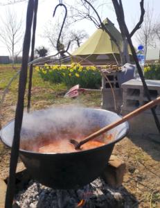 a pot of food cooking on a fire at BELLTENT SAVICA in Zagreb