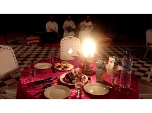 a table with a candle and plates of food on it at kasbah Dar Bahnini in Skoura