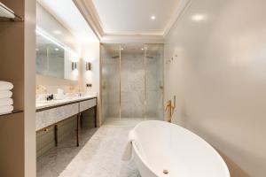 La salle de bains blanche est pourvue d'une baignoire et d'une douche. dans l'établissement Hotel 717, à Amsterdam