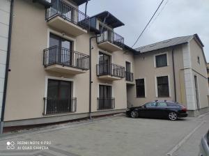 a black car parked in front of a building at Cozy loft apartament in Sighetu Marmaţiei