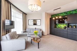 salon z kanapą i telewizorem w obiekcie VacationClub – Diune Resort Apartament 312 w Kołobrzegu