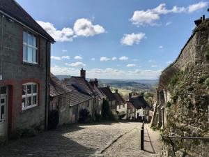 an empty street in a village with buildings at Jasmine Cottage in Iwerne Minster