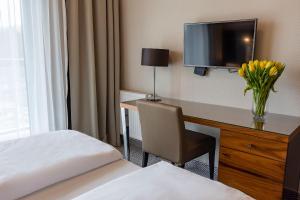 Pokój hotelowy z biurkiem, telewizorem i krzesłem w obiekcie VacationClub – Diune Resort Apartament 312 w Kołobrzegu +8 zdjęć
