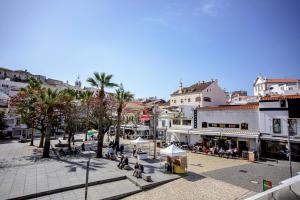 a city street with a group of people and buildings at Musical Hostel in Albufeira