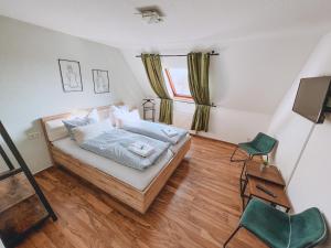 a bedroom with a bed and a window and a chair at Hotel Schwarzach am Main in Schwarzach am Main