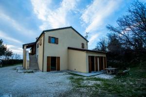 una pequeña casa blanca con una escalera al lado en Agriturismo Conero, en Ancona