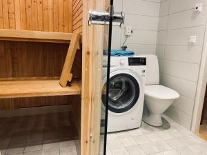 a bathroom with a washing machine and a toilet at Nommen Fishing Cottages in Vetlanda +37 photos