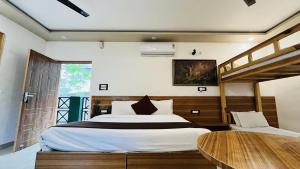 Un dormitorio con una cama grande y una mesa de madera. en Green Hills Cottage Rishikesh, en Rishīkesh