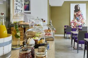 デュッセルドルフにあるホテル インディゴ デュッセルドルフ ヴィクトリアプラッツのテーブル席のビュッフェ式レストラン