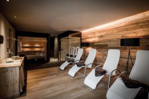 a salon with white chairs and a wooden wall at K Lodge in Valdaora