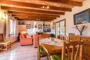 ein Esszimmer mit Tisch und ein Wohnzimmer in der Unterkunft Fontxica in El Port