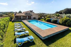 einen Blick über einen Pool mit Liegestühlen und ein Haus in der Unterkunft Fontxica in El Port