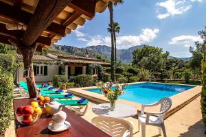 una piscina con sedie e un tavolo con frutta di La Plana a Pollença