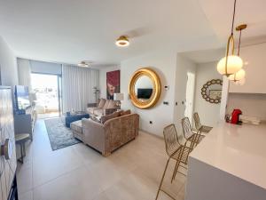a living room with a couch and a mirror at Sunset Waves 3 Benidorm in Benidorm