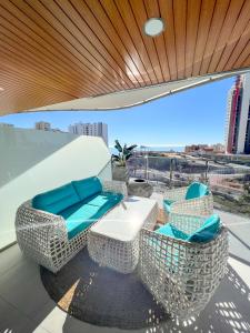 a balcony with chairs and a table on a roof at Sunset Waves 3 Benidorm in Benidorm