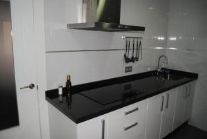 a kitchen with a black counter top and a sink at Casa Centro Histórico Almería - Jayrán in Almería