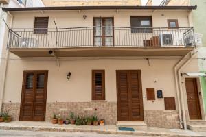 een appartementencomplex met een balkon en planten bij Casa Siria in Balestrate