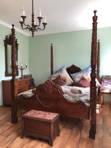 a bedroom with a large wooden bed and a table at Villa Hainberg in Rauschenbach