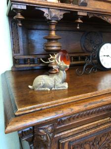 un reloj de madera con una estatua de un reno sentado en un estante en Villa Hainberg, en Rauschenbach