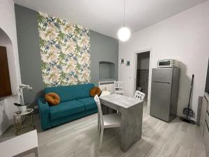 Arcaroli Borgo Vico "La casetta" في فيكو دل غراغانو: غرفة معيشة مع أريكة زرقاء وطاولة
