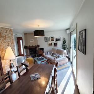 a living room with a table and a couch at Aux Portes du Petit Bois in Sainte-Marie-la-Blanche