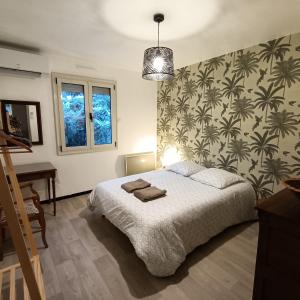 1 dormitorio con cama, escritorio y pared en Aux Portes du Petit Bois en Sainte-Marie-la-Blanche