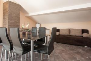 ein Esszimmer mit einem Tisch und einem Sofa in der Unterkunft Apartments TM in Krk