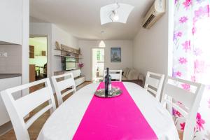 a kitchen and dining room with a pink table and chairs at Apartment Lidija in Dubrovnik