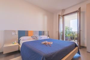 een slaapkamer met een groot bed met een blauwe sprei bij Casole Living B&B in Copertino